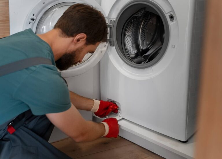 Appliance repair technician servicing washer drain filter and performing maintenance in Tampa