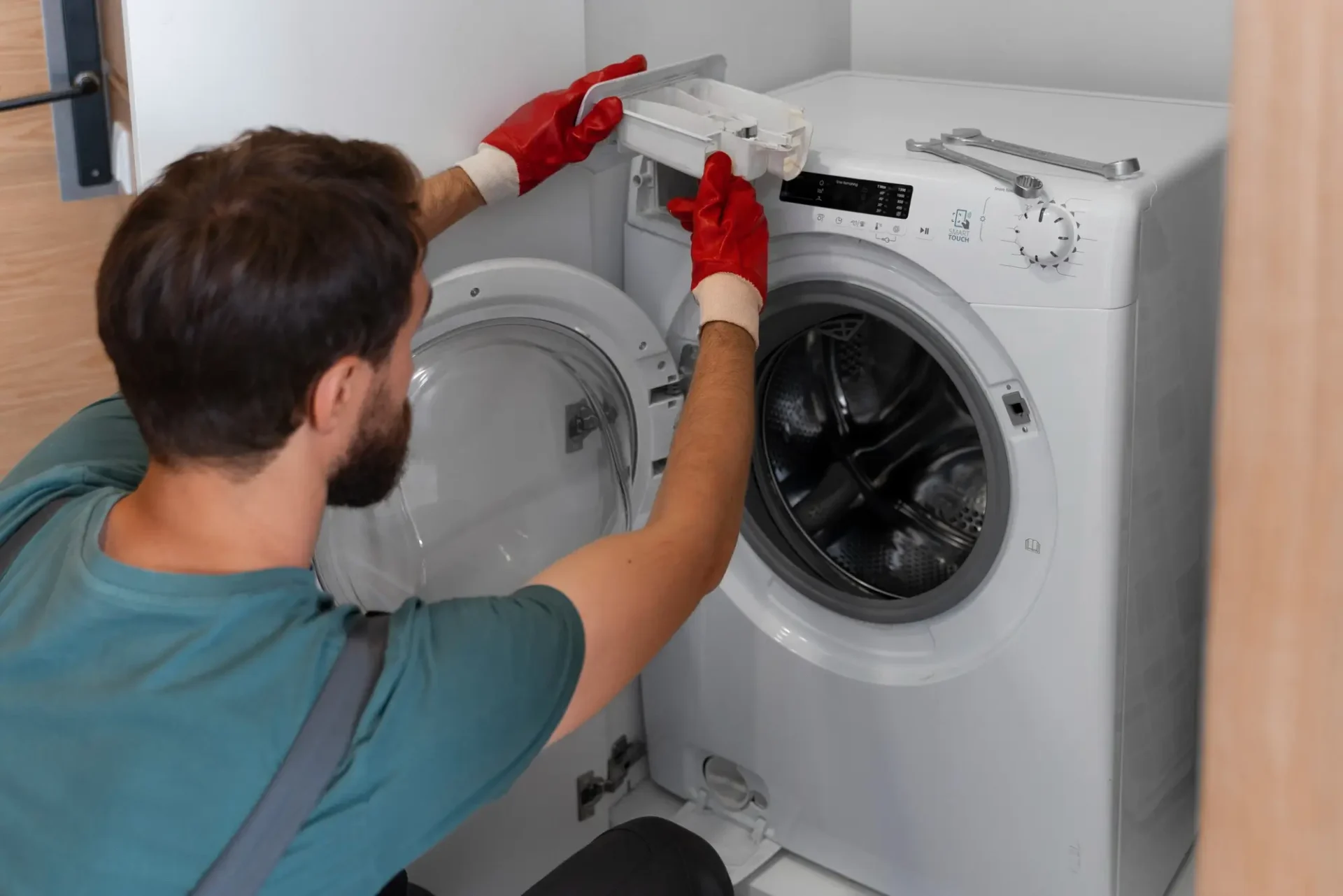 Appliance repair technician removing detergent drawer during front-load washer repair in Tampa