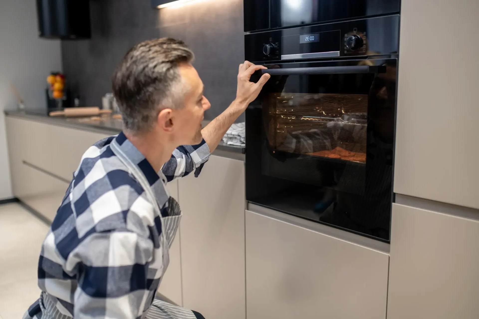 Homeowner adjusting settings on built-in wall oven in modern Tampa kitchen