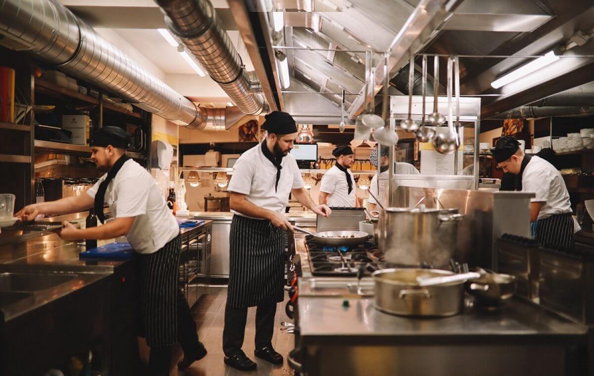 Commercial restaurant kitchen with chefs cooking on multiple appliances in Tampa Bay