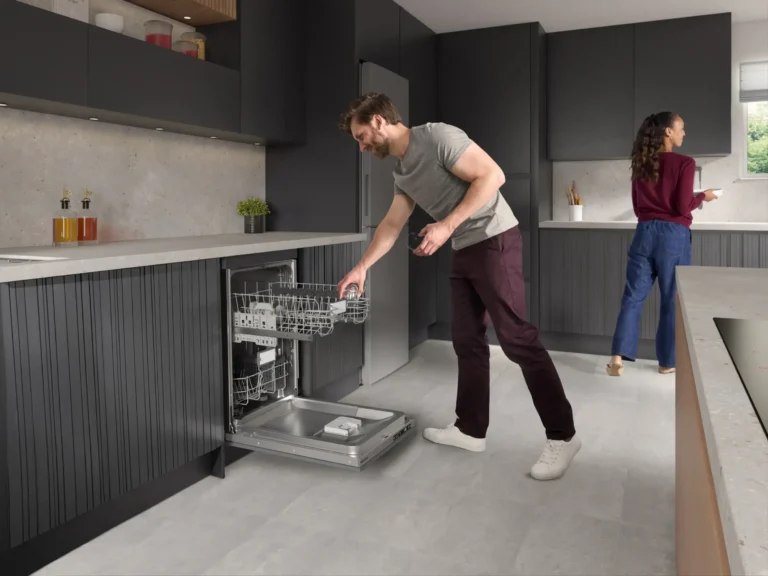 Home dishwasher repair in modern kitchen, technician inspecting lower rack in Tampa Bay home