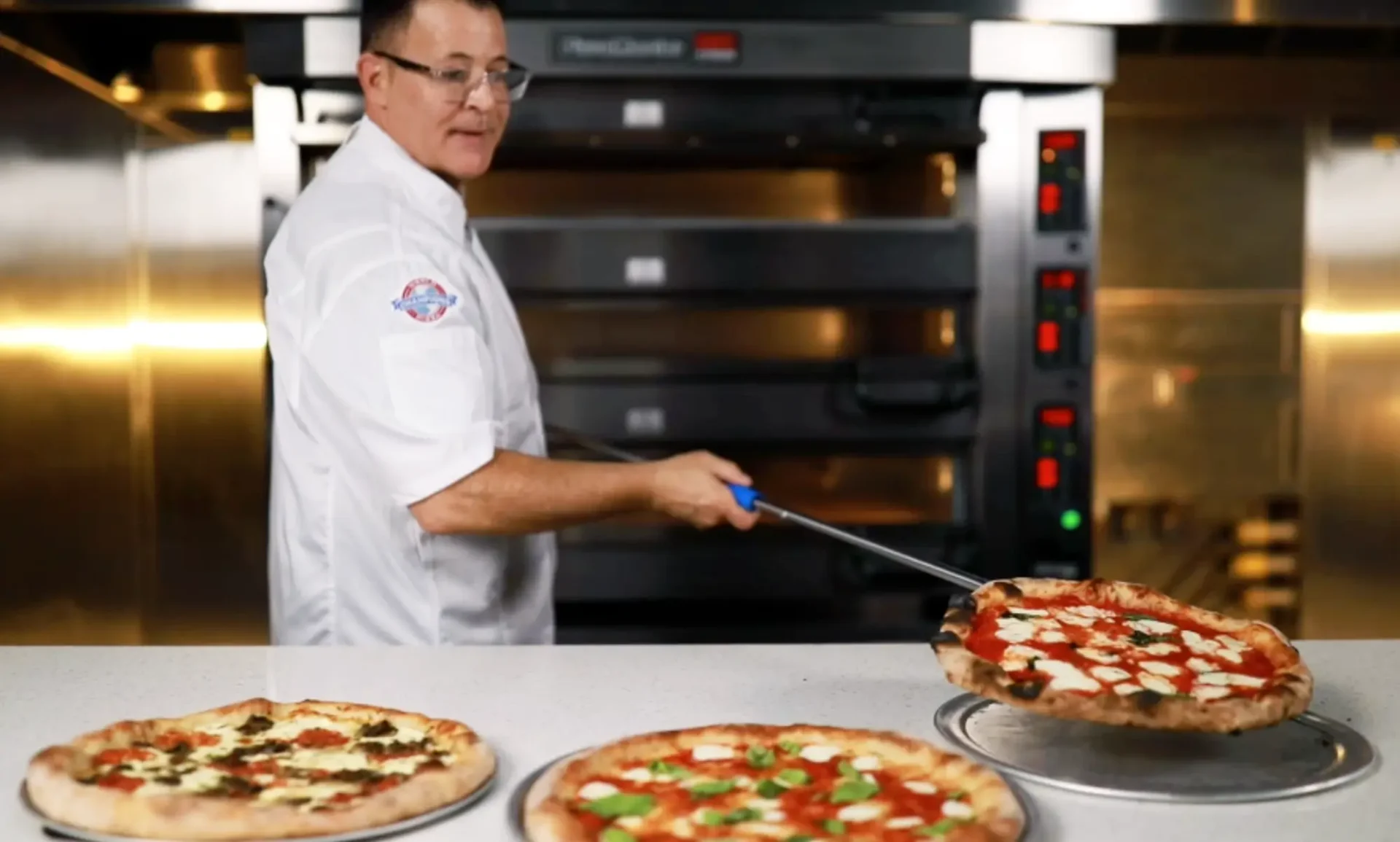 Chef removing fresh pizza from commercial pizza oven in Tampa restaurant
